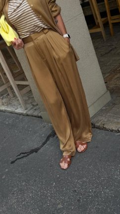 camel široké nohavice na žene s lesklou košeľou v elegantnom outfite