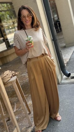 camel široké nohavice na žene s lesklou košeľou v elegantnom outfite camel široké nohavice na žene s lesklou košeľou v elegantnom outfite