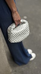bielo šedá kožená kabelka s prepletanou štruktúrou kože v rukách modelky