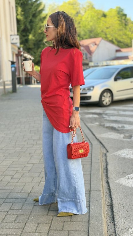 červená kožená mini kabelka so zlatou reťazou a prešívaným povrchom v rukách ženy