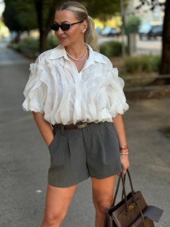 Biela volánová blúzka Florence s košeľovým golierom, krátkym rukávom a plastickou štruktúrou na modelke. Biela volánová blúzka Florence s košeľovým golierom, krátkym rukávom a plastickou štruktúrou na modelke.