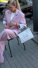 biela kožená kabelka na rameno s kovovým detailom na žene