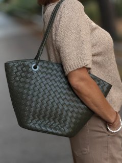 Zelená kožená shopper kabelka Elara Militare s prepletaným dizajnom na ramene modelky.