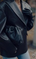 čierna kožená kabelka s mäkkým pouch tvarom v elegantnom mestskom outfite