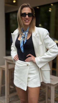 biely skort s prekladaným predným dielom a štruktúrovaným materiálom na elegantnej postave