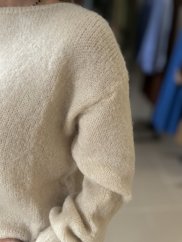Dámsky sveter z moheru a vlny v béžovej farbe, jemná textúra, dlhý rukáv, elegantný jesenný outfit.