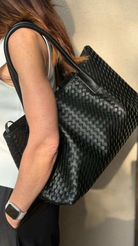 čierna prepletaná kožená kabelka na ramene ženy v elegantnom mestskom outfite čierna prepletaná kožená kabelka na ramene ženy v elegantnom mestskom outfite