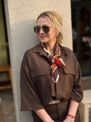 hnedá vzorovaná šatka uviazaná okolo krku ženy k elegantnému outfitu