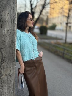 hnedá koženková midi sukňa s rozparkom na žene v elegantnom mestskom outfite