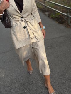 Béžové koženkové bermudy Atelier s jemnou štruktúrou materiálu, vyšším pásom a elegantným mestským stylingom na modelke.