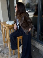 tmavomodré široké dámske nohavice elegantného strihu nosené v mestskom outfite tmavomodré široké dámske nohavice elegantného strihu nosené v mestskom outfite