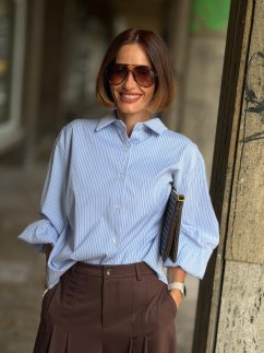 Modrá prúžkovaná košeľa Celeste Blue s golierom a voľnejším strihom na modelke. Modrá prúžkovaná košeľa Celeste Blue s golierom a voľnejším strihom na modelke.