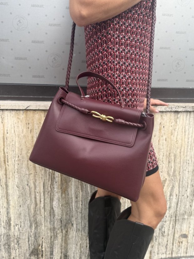 Burgundy kožená kabelka so zlatou sponou a prepletaným detailom, elegantný taliansky dizajn.