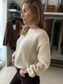 Dámsky sveter z moheru a vlny v béžovej farbe, jemná textúra, dlhý rukáv, elegantný jesenný outfit. Dámsky sveter z moheru a vlny v béžovej farbe, jemná textúra, dlhý rukáv, elegantný jesenný outfit.