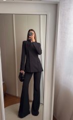 čierny elegantný kostým s tvarovaným sakom a rozšírenými nohavicami na postave čierny elegantný kostým s tvarovaným sakom a rozšírenými nohavicami na postave
