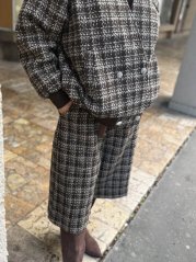 Hnedé kárované bermudy Marrone s elegantným voľným strihom a gombíkmi, jesenný outfit. Hnedé kárované bermudy Marrone s elegantným voľným strihom a gombíkmi, jesenný outfit.