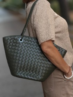 Zelená kožená shopper kabelka Elara Militare s prepletaným dizajnom na ramene modelky.