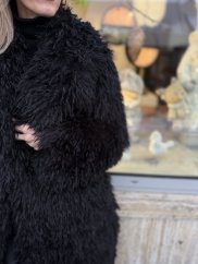 čierny dlhý dámsky kožúšok s výraznou textúrou v mestskom outfite