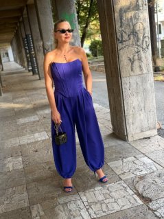 Modré široké nohavice Milano Viola so skladmi v páse, voľným strihom a jemne stiahnutým spodným lemom na modelke. Modré široké nohavice Milano Viola so skladmi v páse, voľným strihom a jemne stiahnutým spodným lemom na modelke.