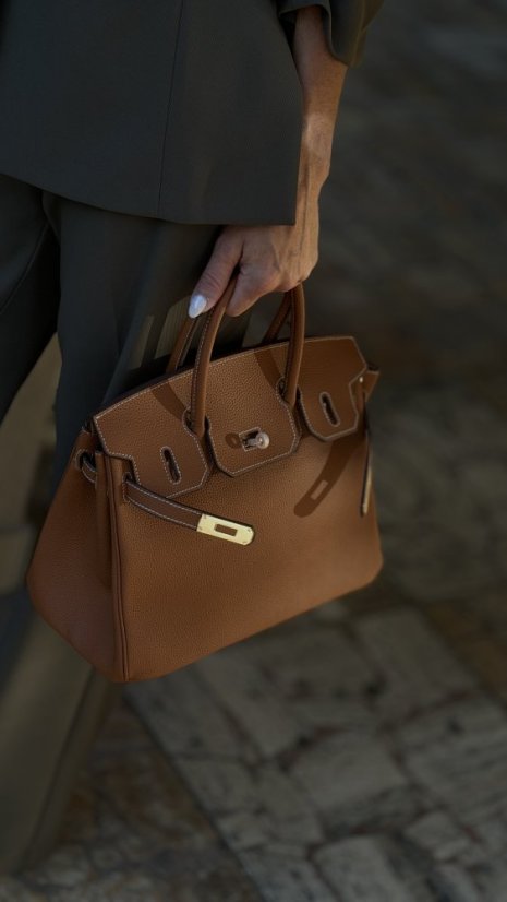 hnedá kožená kabelka s krátkymi rúčkami a zlatým zapínaním v elegantnom štýle