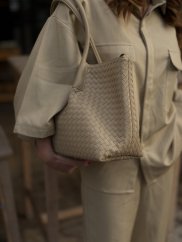 béžová shopper kabelka s prepletanou textúrou na ramene ženy
