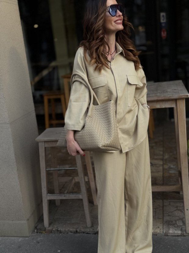 béžová shopper kabelka s prepletanou textúrou na ramene ženy