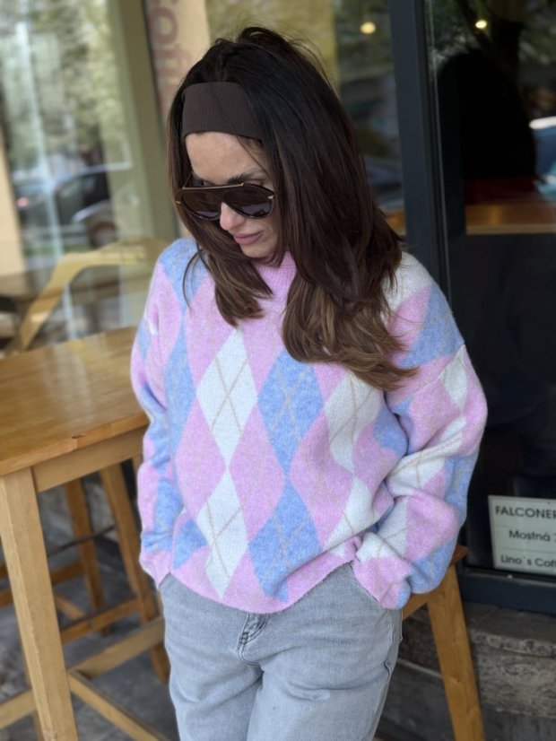 pastelový argyle sveter v ružovej a modrej na žene v svetlých rifliach