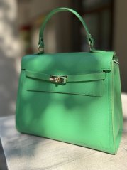 Zelená kožená kabelka so zlatým zapínaním, elegantný doplnok a farebný akcent outfitu