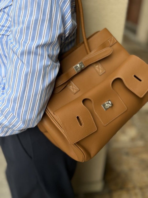 Hnedá kožená kabelka s pevnou konštrukciou a elegantným minimalistickým dizajnom