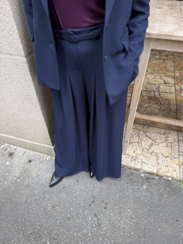 Dámsky tmavomodrý kostým so sakom a širokými nohavicami, elegantný business outfit s moderným strihom.