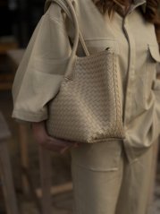 béžová shopper kabelka s prepletanou textúrou na ramene ženy