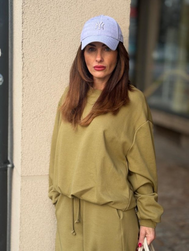 olivová mikina s nariaseným rukávom na žene v ležérnom outfite