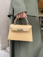 Krémová kožená mini kabelka so zlatým zapínaním a pevným držadlom v elegantnom štýle
